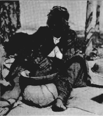 MARIA LUGO, POUNDING ACORNS AT CAHUILLA, SHOWING THE KA-KA-WOHL OR ACORN MORTAR