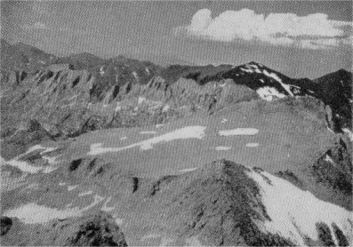 Looking north from Mount Conness. In the lower part of the view is the nivated west slope of North Peak. A bit of the upland surface on Shepherd’s Crest is visible in the left middle distance, at the far end of a long arte.  By Richard M. Leonard