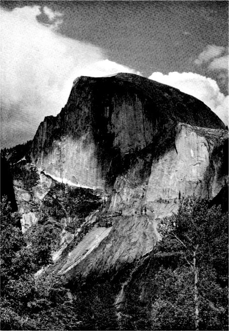 Half Dome rears its granite crest more than a mile above the floor of the Yosemite Vatley, surviving the storms of the ages. By Ansel Adams