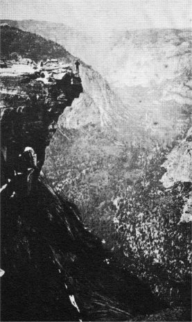 George Anderson on the lip of Half Dome; Yosemite Valley below